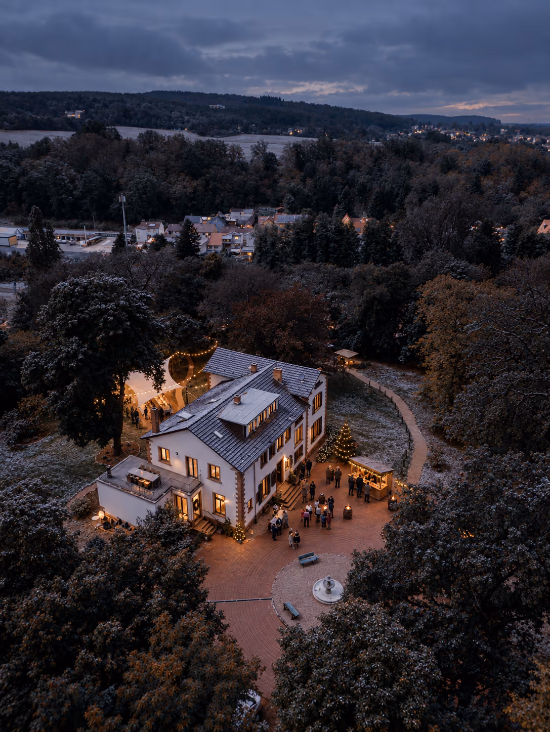 Einfahrt der Villa Renting in Eisenberg (Pfalz) am Winterabend mit Lichterkette, Laternen und Schnee auf dem Pflaster