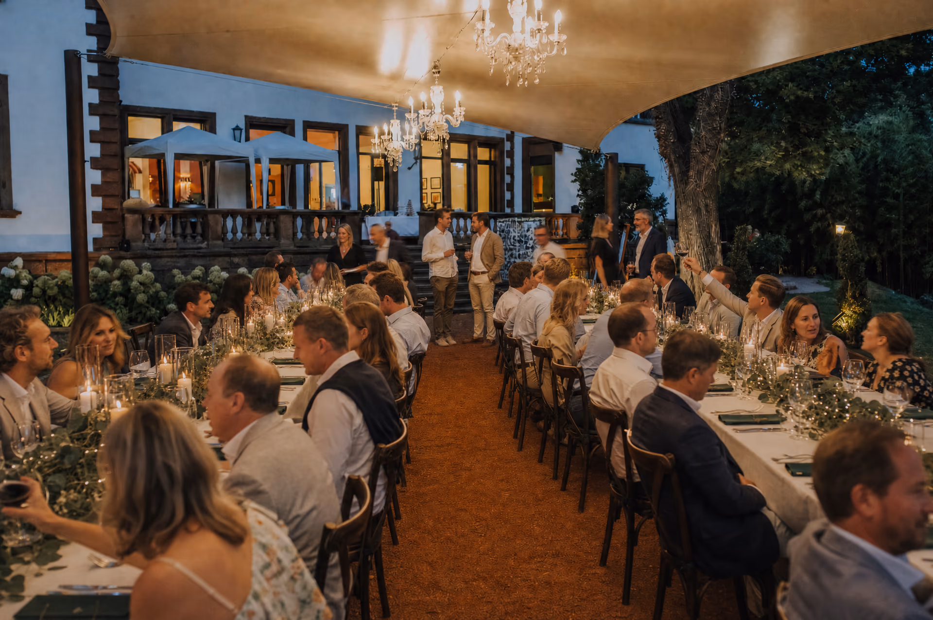 Eventlocation Pfalz Villa Renting Eisenberg — Firmentafel im überdachten Außenbereich am Abend