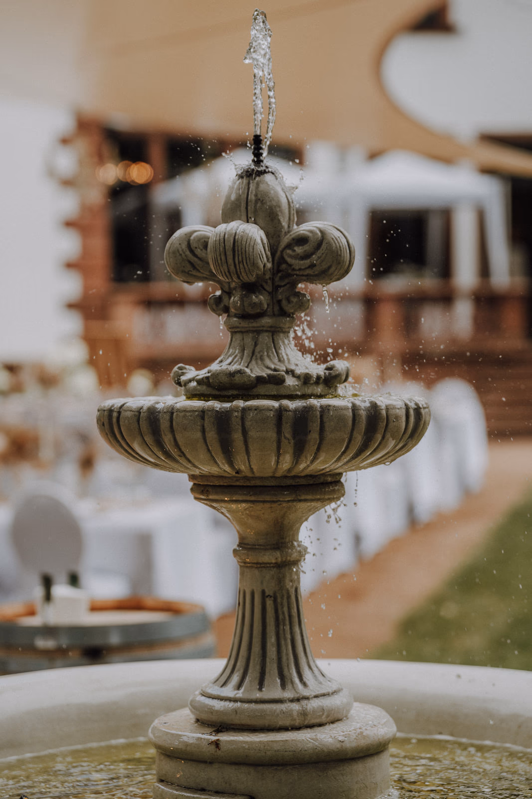 Steinbrunnen und eingedeckte Tische im Park der Villa Renting Eisenberg Pfalz