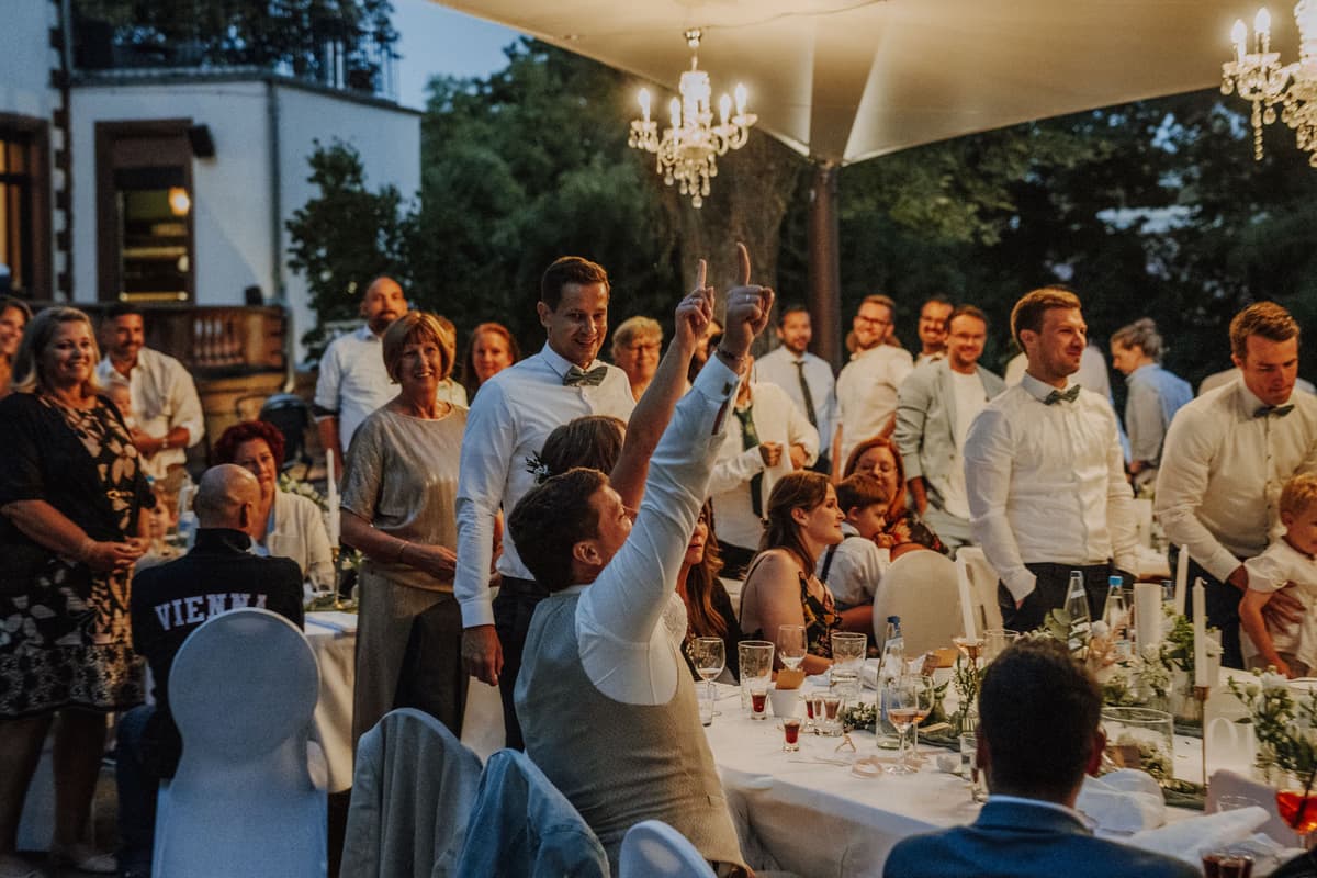 Gäste erheben die Gläser beim Abenddinner unter dem Kronleuchter, Villa Renting Eisenberg Pfalz