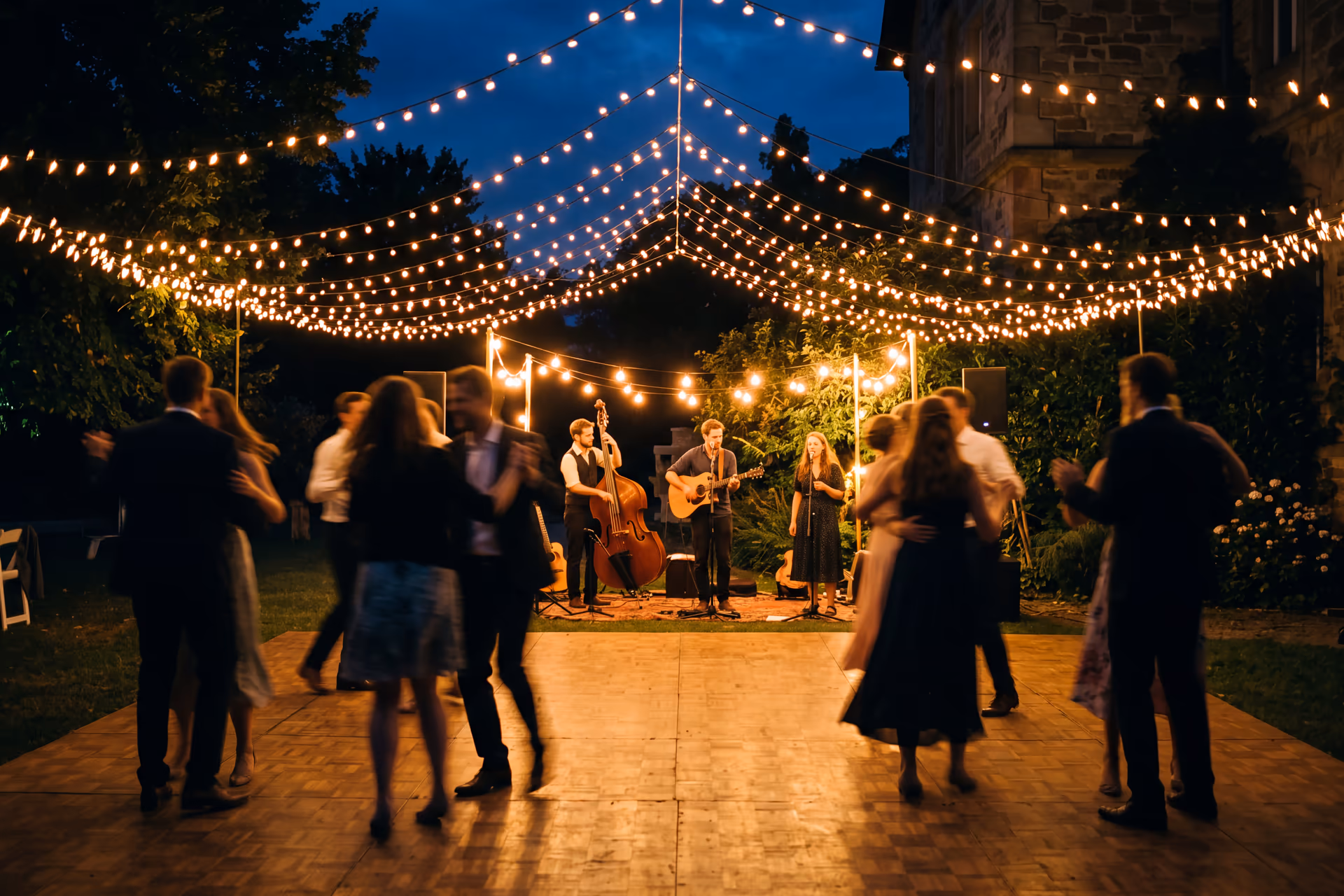 Tanzfläche unter Lichterketten mit Live-Band am Abend — Hochzeitsmusik Playlist Villa Renting Eisenberg Pfalz