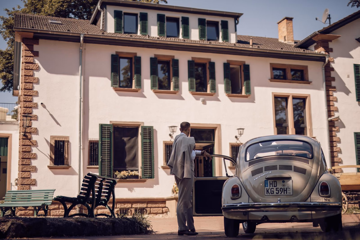 Vintage VW Beetle in front of Villa Renting Eisenberg with green window shutters