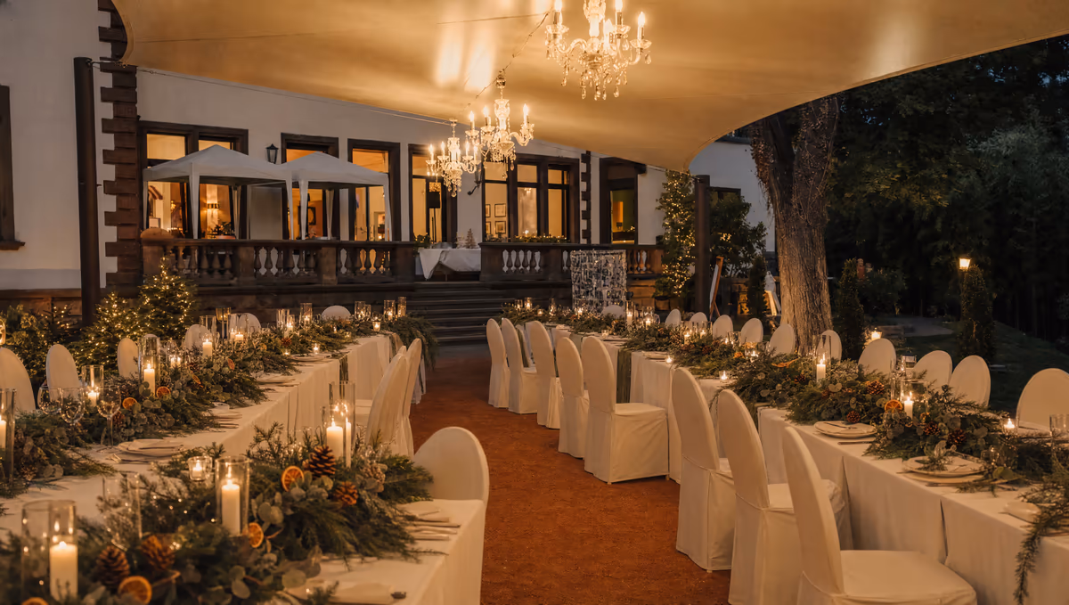 Lange Hochzeitstafel mit Tannengrün, Kerzen und getrockneten Orangenscheiben im überdachten Außenbereich der Villa Renting Eisenberg Pfalz